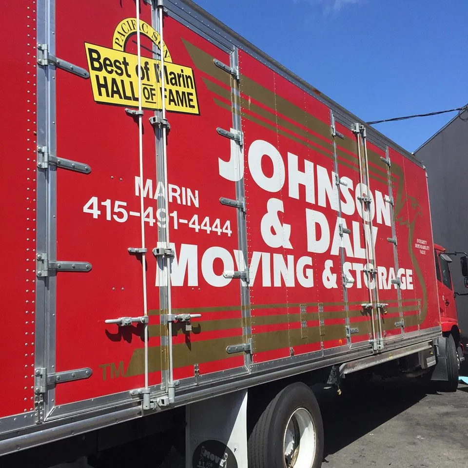 Picture of A red moving truck bearing the Johnson & Daly Moving & Storage logo stands proudly in the sunlight, its surface adorned with a "Best of Marin Hall of Fame" badge, symbolizing its top-rated quality service. The company is recognized for expertise and quality. Copyright ©2025 Diamond Certified Resource

 - Johnson & Daly Moving & Storage