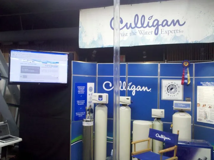 Culligan Water display booth featuring water treatment equipment, banners, and a computer screen. Culligan Water display booth featuring water treatment equipment, banners, and a computer screen.