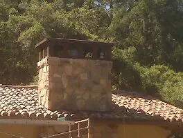 Picture of  A sturdy stone chimney stands against a backdrop of lush trees, exemplifying the craftsmanship Enviro Heating & Air Conditioning, Inc. is known for. With a focus on quality outcomes, they ensure every project enhances comfort and efficiency. Copyright ©2025 Diamond Certified Resource.

 - Enviro Heating & Air Conditioning, Inc.