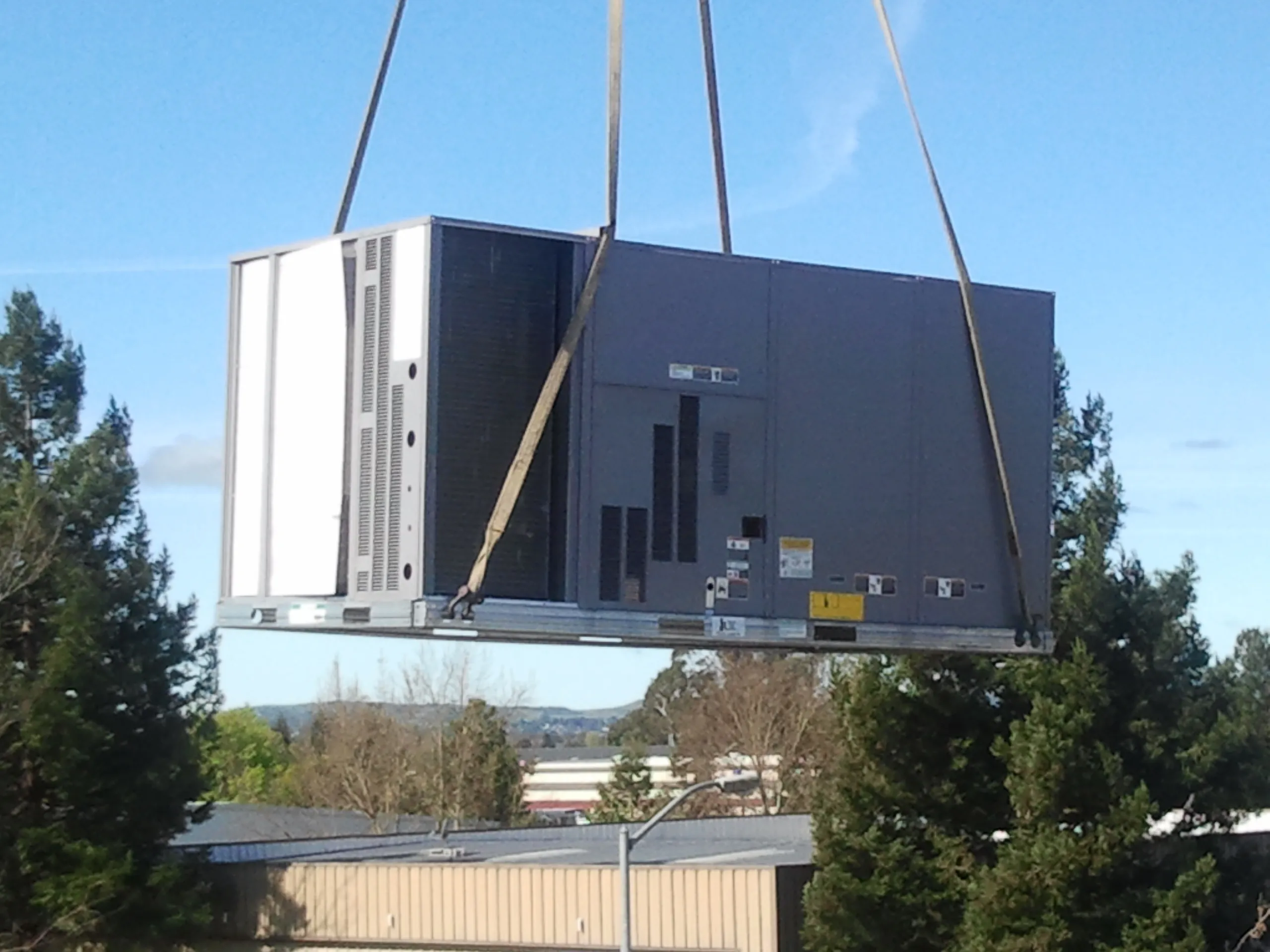 Picture of  Suspended against the blue sky, a large HVAC unit is carefully hoisted into place, illustrating Enviro Heating & Air Conditioning, Inc.'s commitment to quality outcomes in installation. The company's focus on quality ensures optimal performance and customer satisfaction. Copyright ©2025 Diamond Certified Resource.

 - Enviro Heating & Air Conditioning, Inc.