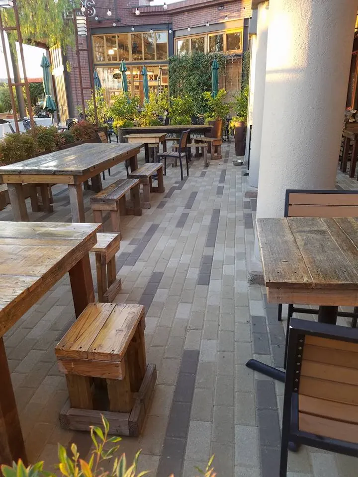 Picture of Rustic wooden tables and benches rest on meticulously laid pavers, creating a harmonious outdoor space. The Legacy Paver Group is recognized for expertise and quality, crafting inviting environments like this one. Copyright ©2025 Diamond Certified Resource

 - The Legacy Paver Group