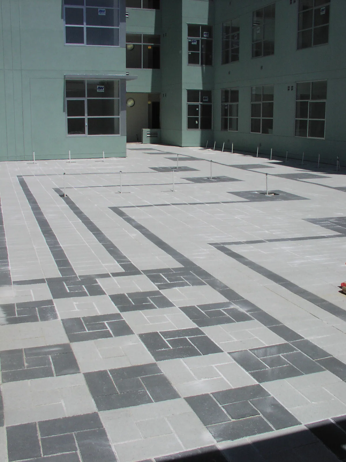 Picture of Intricate patterns of light and dark paving stones form a striking geometric design in a modern courtyard, exemplifying The Legacy Paver Group's focus on quality outcomes. Recognized for expertise and quality. Copyright ©2025 Diamond Certified Resource

 - The Legacy Paver Group