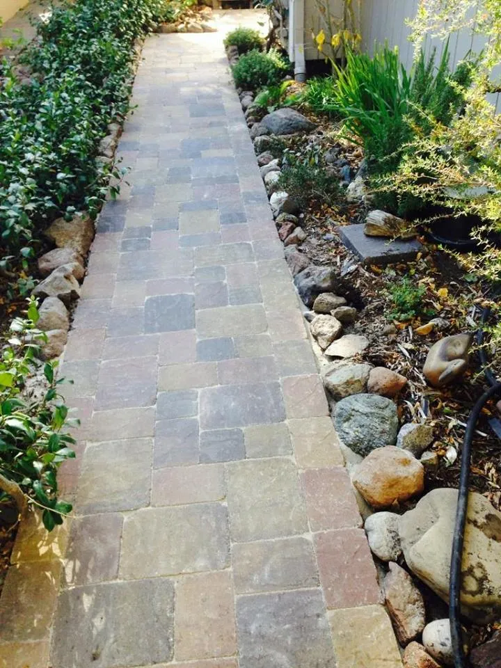 Picture of A meticulously crafted stone pathway, flanked by lush greenery and decorative rocks, highlights The Legacy Paver Groupâ€™s dedication to quality outcomes. This serene path is a testament to their expertise and high customer satisfaction. Copyright ©2025 Diamond Certified Resource

 - The Legacy Paver Group