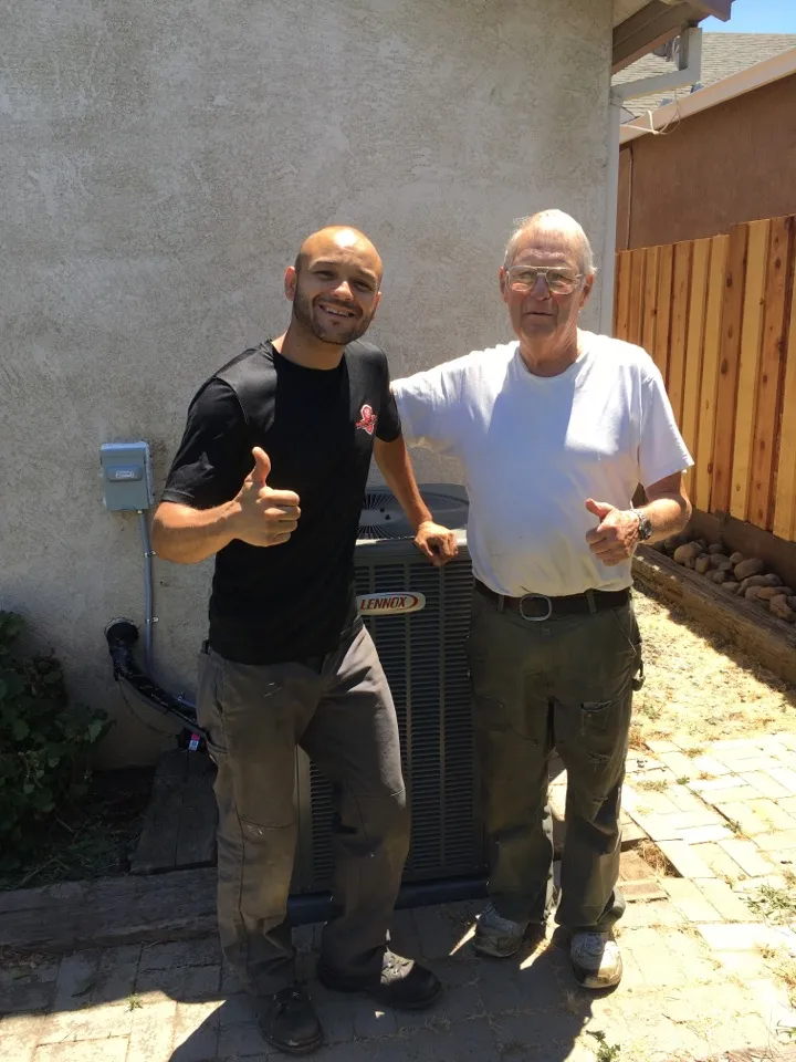 Picture of Lead Install Technician Gilbert Caceres poses with a satisfied client after installing a new Lennox heating and air conditioning system. - Perfect Star Heating, Cooling, & Electrical