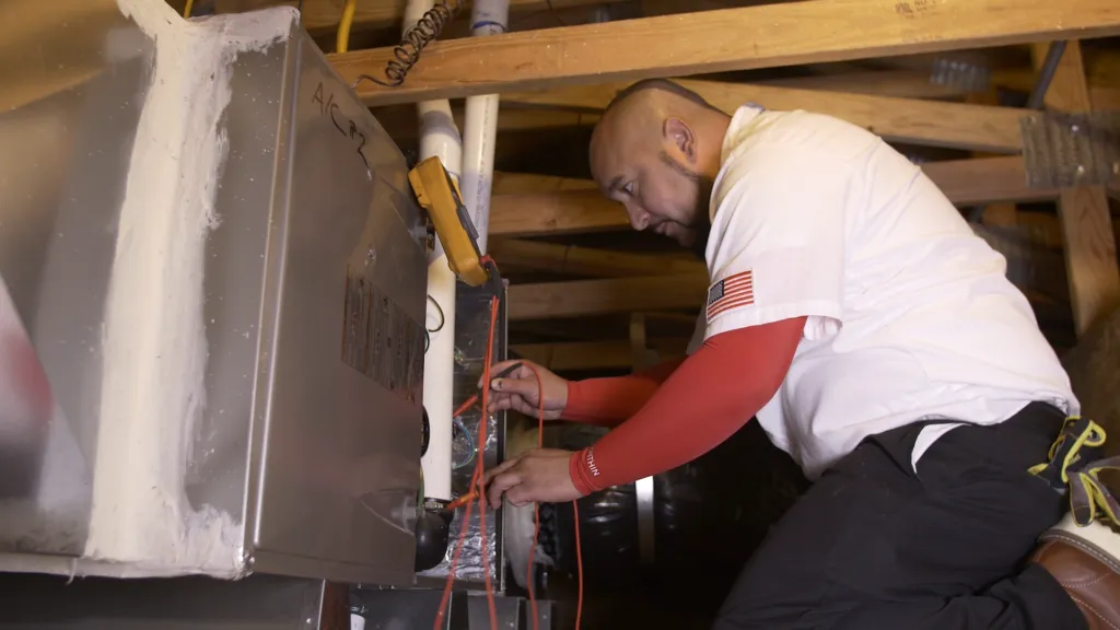 Picture of Senior Comfort Adviser Danny Mendoza services a client's furnace in Brentwood. - Perfect Star Heating, Cooling, & Electrical