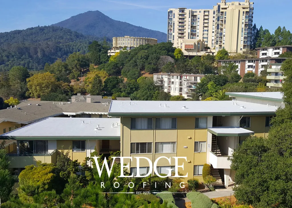 Picture of Elevated view of a residential complex with pristine white roofs, set against a mountainous backdrop. Wedge Roofingâ€™s craftsmanship is evident, embodying their focus on quality outcomes. Copyright ©2025 Diamond Certified Resource

 - Wedge Roofing