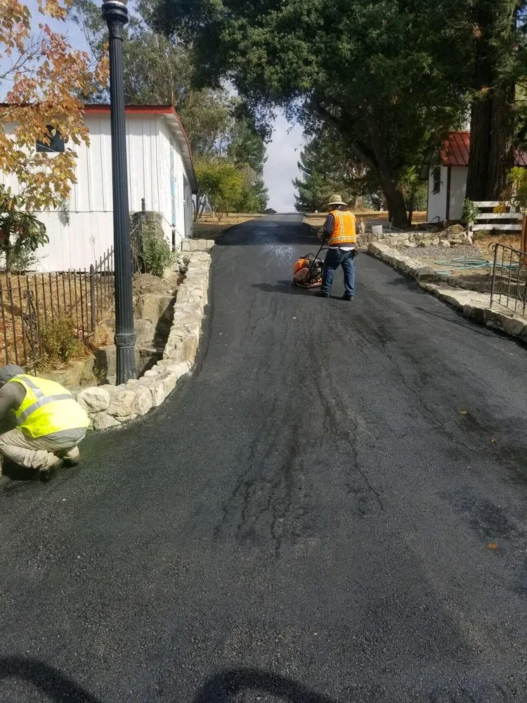 Picture of  A worker carefully operates a compactor on a freshly paved driveway, embodying Jackson's Paving & Equipment Rentals, Inc.'s focus on quality outcomes. The company consistently achieves the highest ratings for quality, ensuring lasting results. Copyright ©2025 Diamond Certified Resource.

 - Jackson's Paving & Equipment Rentals, Inc.