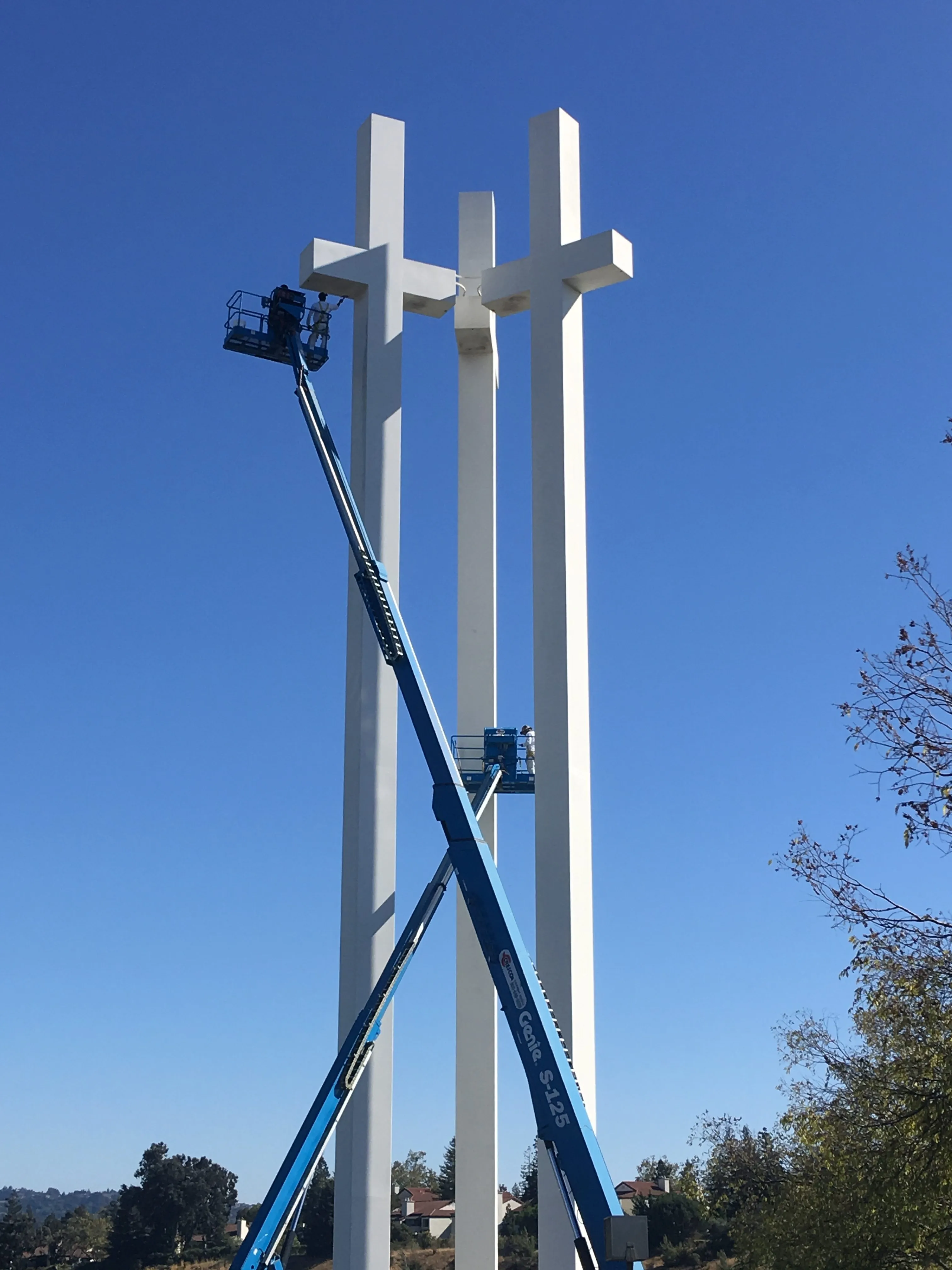 Picture of  Elevated high against a brilliant blue sky, S & S Painting and Coatings, Inc. attends to the towering crosses with meticulous care, embodying their focus on quality outcomes. Copyright ©2025 Diamond Certified Resource.

 - S & S Painting and Coatings, Inc.
