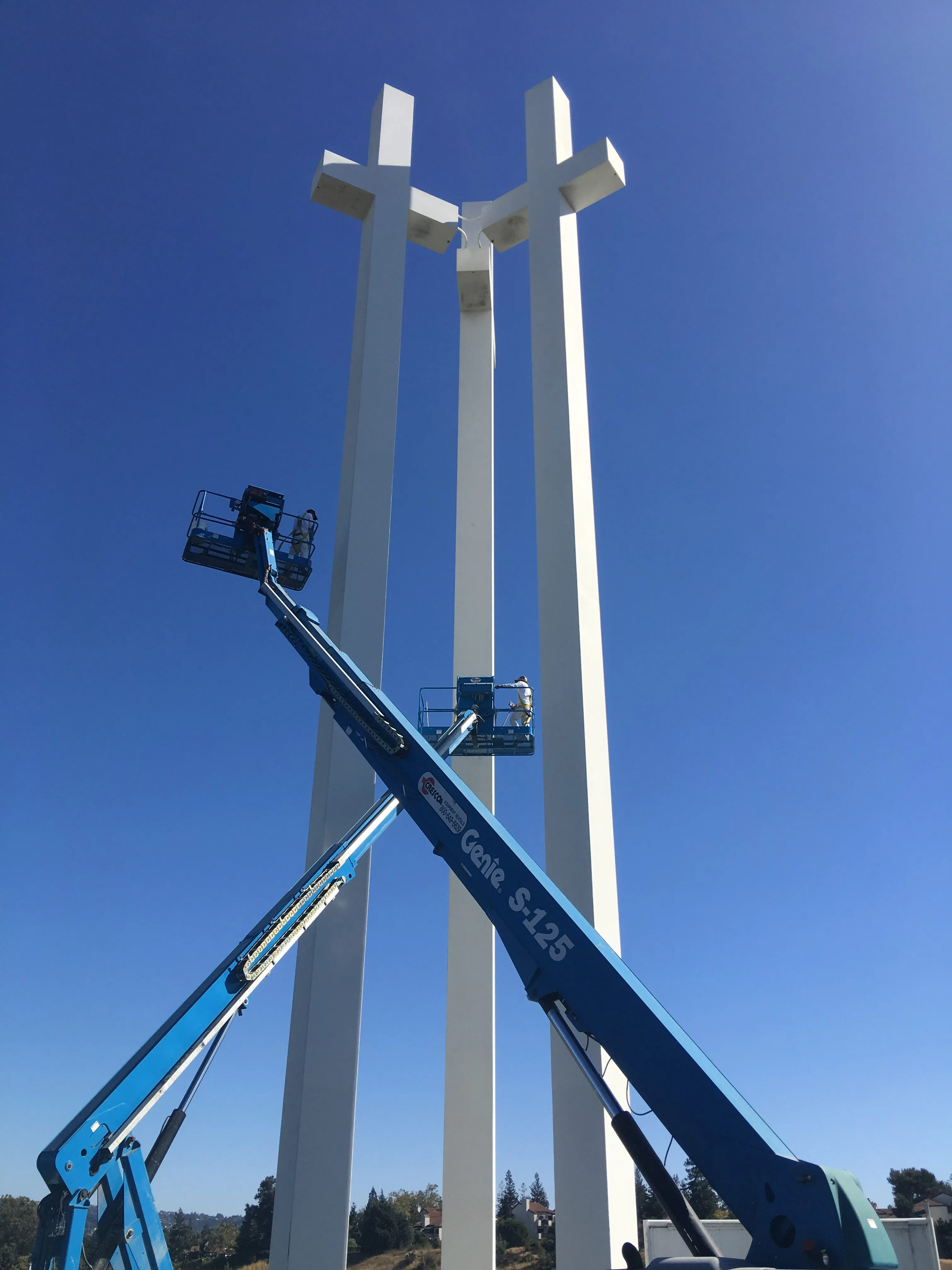 Picture of  Amidst a clear blue sky, S & S Painting and Coatings, Inc. undertakes the meticulous task of maintaining towering structures, a testament to their earned Diamond Certified status. Copyright ©2025 Diamond Certified Resource.

 - S & S Painting and Coatings, Inc.