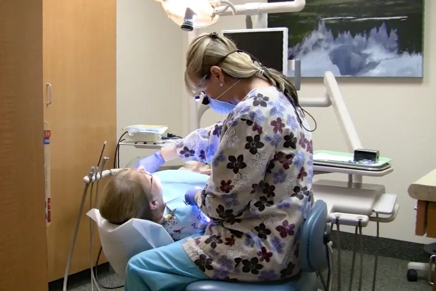 Picture of In a serene dental office, a dentist at William M. Schneider, D.D.S. focuses on quality outcomes as they attend to a young patient, underlining the practice's dedication to top-rated care. Copyright ©2025 Diamond Certified Resource

 - William M. Schneider, D.D.S.