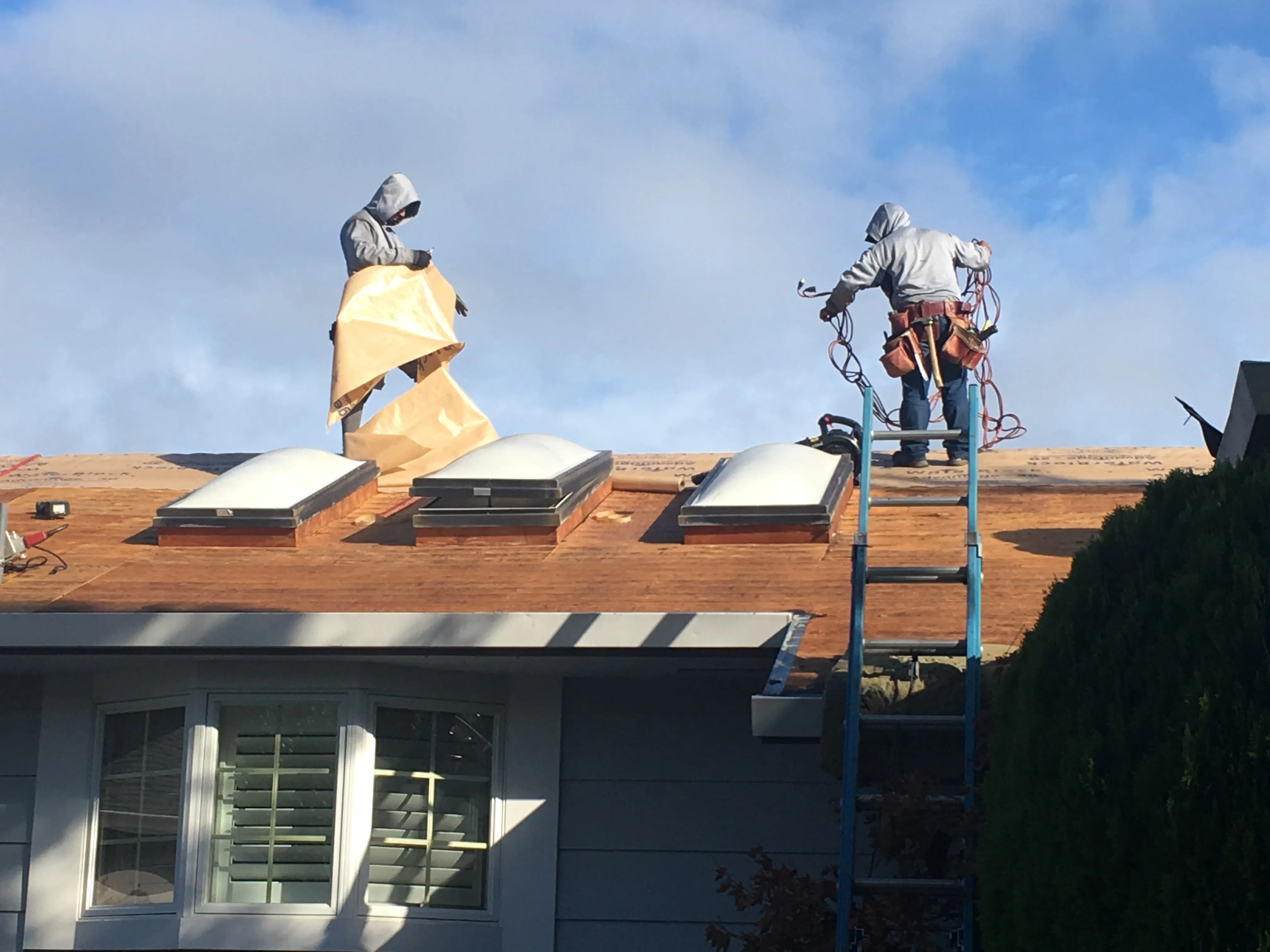 Picture of Under a crisp blue sky, Capstone Roofing, Inc. artisans carefully navigate the rooftop, preparing materials for installation. Their precision reflects the company’s commitment to quality outcomes. Copyright ©2025 Diamond Certified Resource. - Capstone Roofing, Inc.