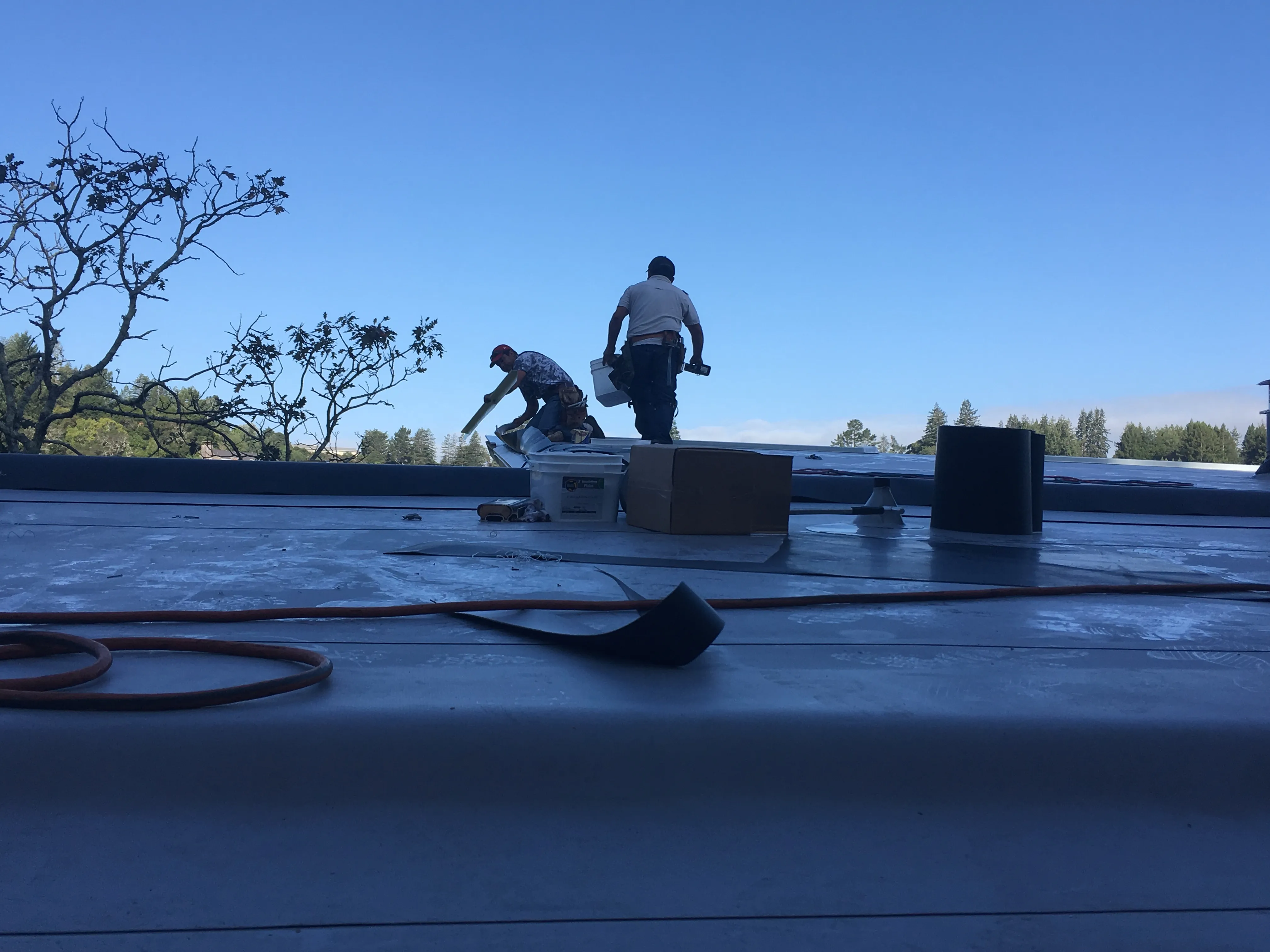 Picture of Under the clear sky, two workers meticulously tend to a rooftop, embodying Capstone Roofing, Inc.'s focus on quality outcomes. Their dedication reflects why the company is consistently top rated for Quality. Copyright ©2025 Diamond Certified Resource. - Capstone Roofing, Inc.