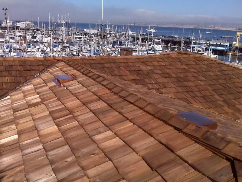 Cedar shake roof with two skylights, overlooking a marina filled with boats and a view of the water beyond. Cedar shake roof with two skylights, overlooking a marina filled with boats and a view of the water beyond.