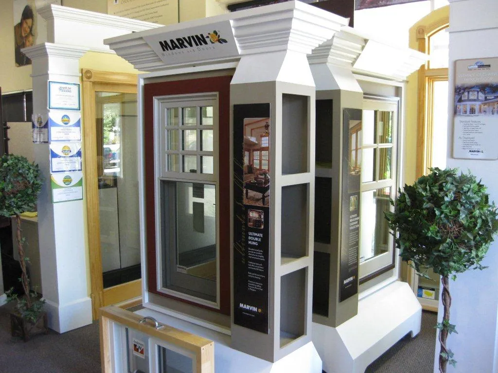 Marvin window display in a showroom with detailed trim, promotional materials, and surrounding decor, showcasing design options. Marvin window display in a showroom with detailed trim, promotional materials, and surrounding decor, showcasing design options.