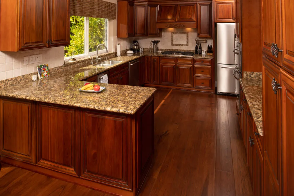 A well-designed kitchen features rich wood cabinets, granite countertops, stainless steel appliances, and a large window with a view of greenery. A well-designed kitchen features rich wood cabinets, granite countertops, stainless steel appliances, and a large window with a view of greenery.