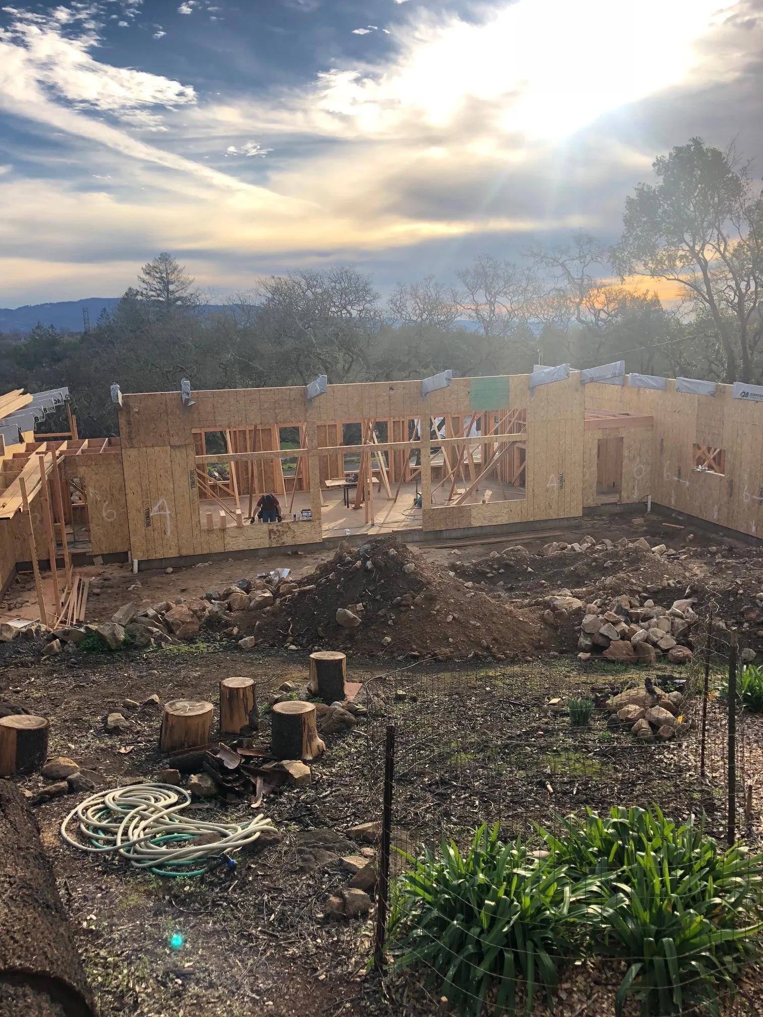 Picture of As the sun sets over the hilly landscape, Evenich Construction, Inc. diligently raises the wooden framework of a new home, embodying their focus on quality outcomes. Copyright ©2025 Diamond Certified Resource. - Evenich Construction, Inc.