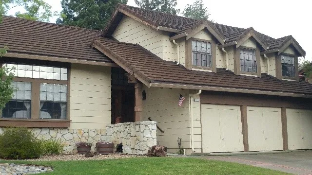 Front view of a two-story house with a freshly painted exterior, featuring brown wooden accents and a landscaped front yard. Front view of a two-story house with a freshly painted exterior, featuring brown wooden accents and a landscaped front yard.