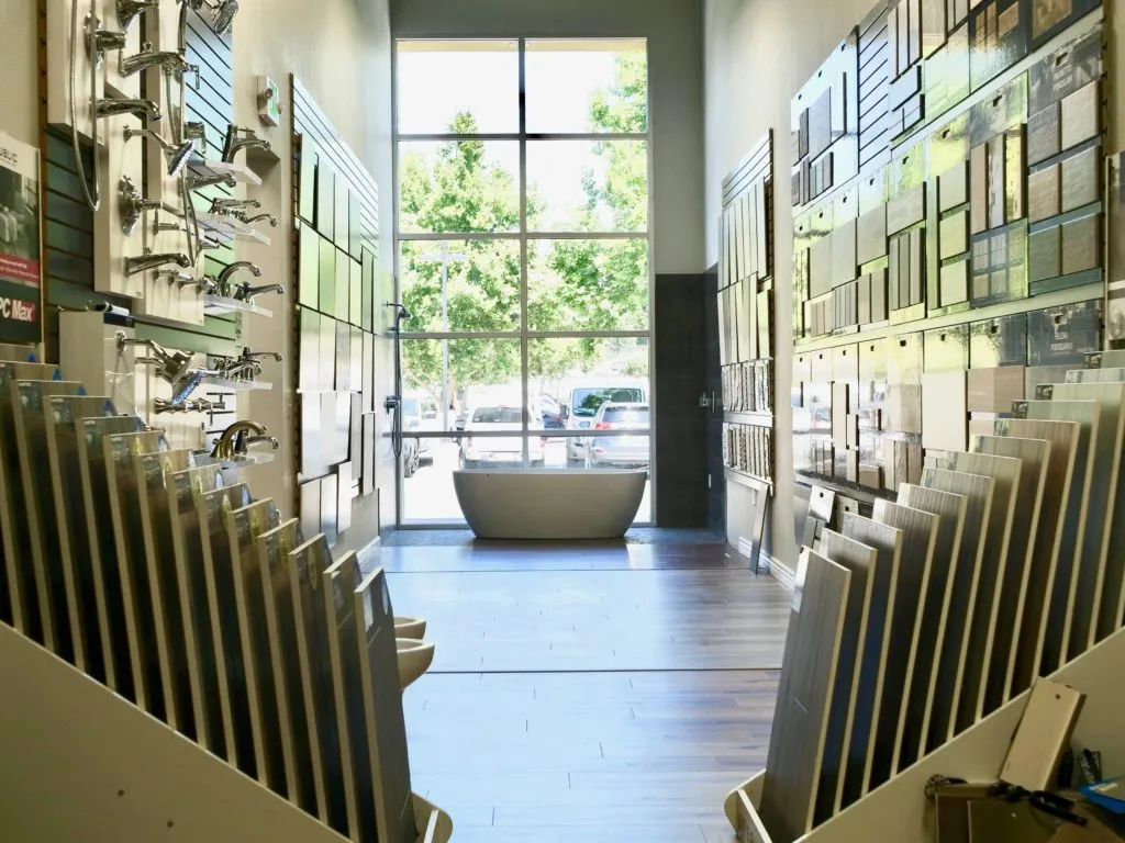 Picture of In the serene expanse of Today's Kitchen & Bath's showroom, a freestanding tub stands proudly framed by floor-to-ceiling windows. Exemplifying their focus on quality outcomes, this curated space invites inspiration. Copyright ©2025 Diamond Certified Resource - Today's Kitchen & Bath