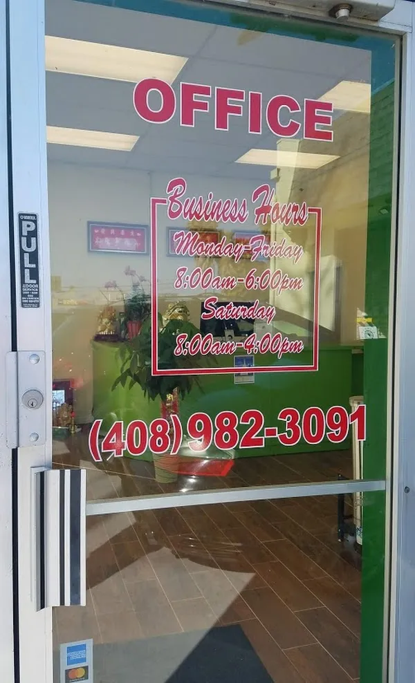  Glass door with the word "OFFICE" and business hours for Monday-Saturday. A glimpse of the interior shows a green counter and decorative plants.