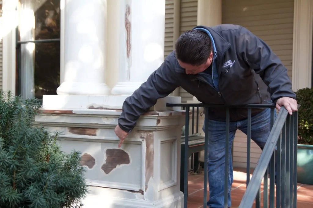 Picture of A craftsman from Stanford Painting, Inc. inspects a column's surface for quality assurance—an emblematic act of their commitment to quality outcomes. Copyright ©2025 Diamond Certified Resource. - Stanford Painting, Inc.
