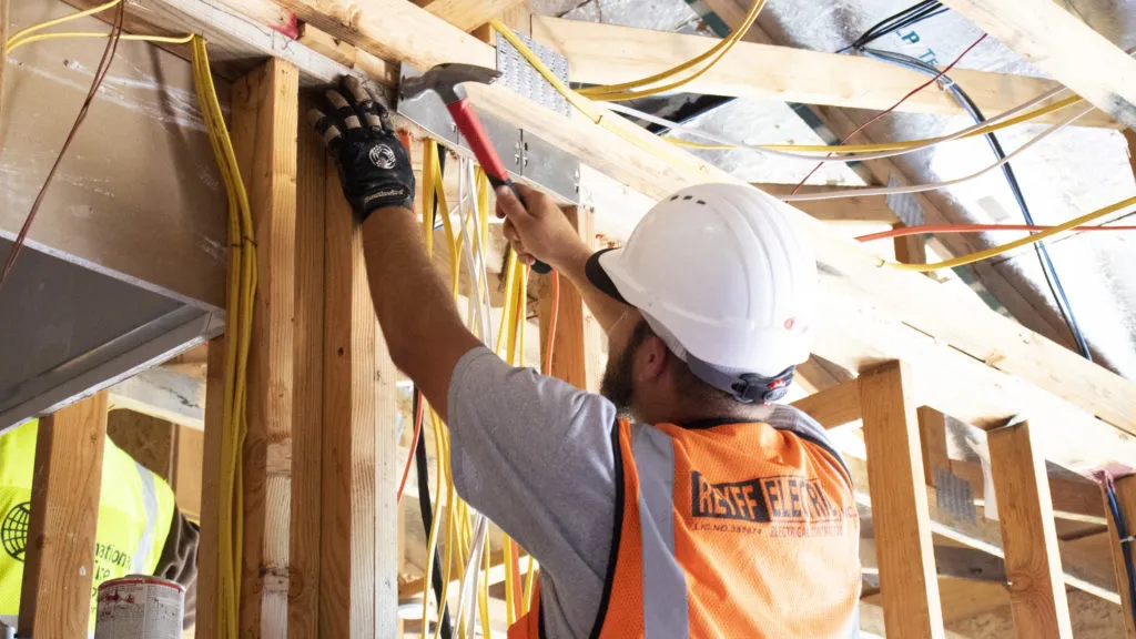 Picture of  A worker from Reyff Electric, Inc. deftly navigates a tangle of wires as he secures structural elements in place. Known for consistently achieving a Highest in Quality rating, Reyff Electric ensures precision in every detail. Copyright ©2025 Diamond Certified Resource.

 - Reyff Electric, Inc.