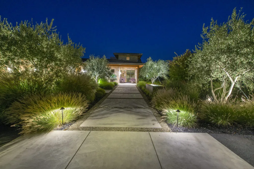 Picture of As twilight descends, pathway lights cast a serene glow on lush greenery, guiding the way to a welcoming home entrance. Reyff Electric, Inc. is recognized for expertise and quality, ensuring every detail shines flawlessly. Copyright ©2025 Diamond Certified Resource. - Reyff Electric, Inc.