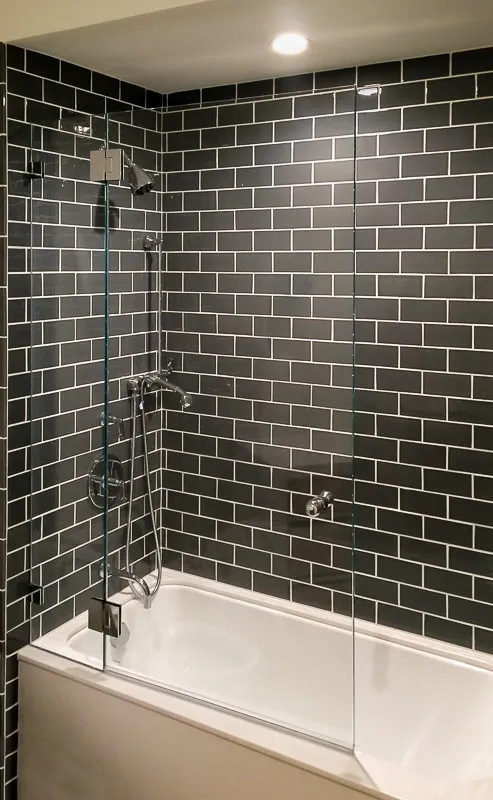 Picture of  In this modern bathroom, sleek glass panels by Schicker Luxury Shower Doors, Inc. seamlessly blend with the dark subway tile backdrop, reflecting the company's focus on quality outcomes. Copyright ©2025 Diamond Certified Resource.

 - Schicker Luxury Shower Doors, Inc.