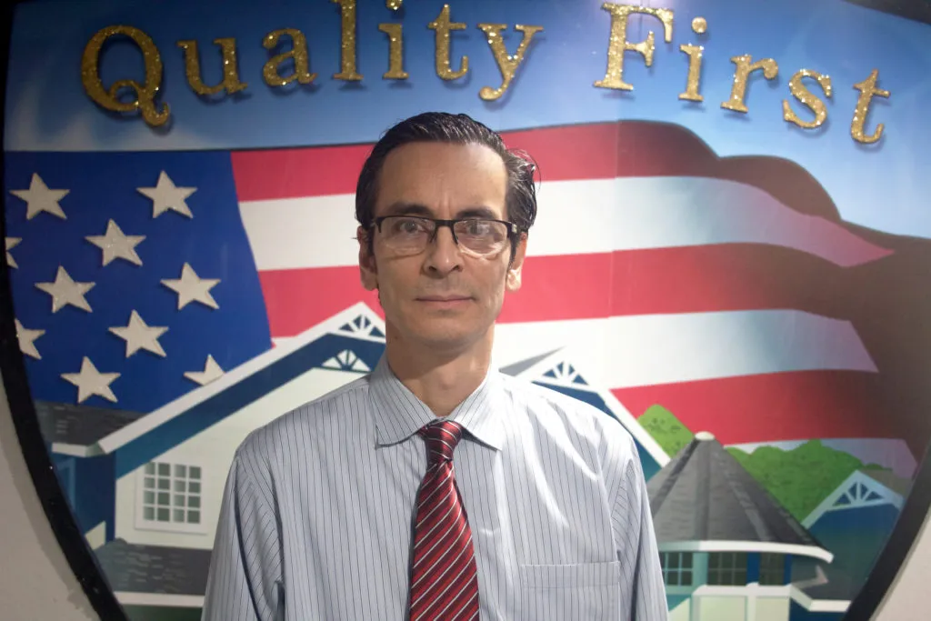 Picture of A professional stands confidently before the emblematic backdrop of Quality First Home Improvement, Inc., symbolizing the company’s dedication to quality outcomes. Recognized for expertise and quality, the company ensures every project reflects its high standards. Copyright ©2025 Diamond Certified Resource. - Quality First Home Improvement, Inc.