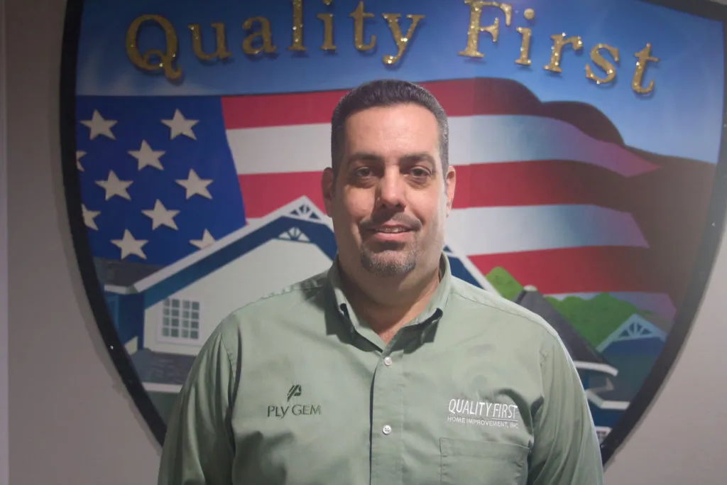 Picture of  Standing proudly before the company’s emblem, a representative of Quality First Home Improvement, Inc. embodies the commitment to quality outcomes that has earned the company high customer satisfaction ratings. Copyright ©2025 Diamond Certified Resource.

 - Quality First Home Improvement, Inc.