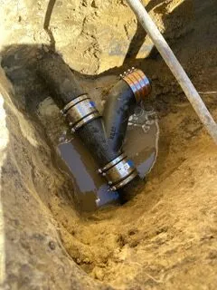 Picture of In the midst of an intricate plumbing repair, a freshly installed Y-connector pipe lies securely fitted in a muddy trench, reflecting Discover Plumbing & Rooter's focus on quality outcomes. Copyright ©2025 Diamond Certified Resource

 - Discover Plumbing & Rooter