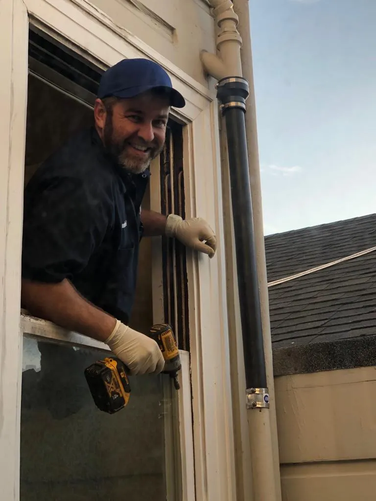 Picture of A skilled technician from Chosen Rooter & Plumbing, Inc. smiles as he expertly installs a new window, showcasing the company’s commitment to quality outcomes. This attention to detail reflects their recognition for expertise and quality, ensuring every project meets high standards. Copyright ©2025 Diamond Certified Resource - Chosen Rooter & Plumbing, Inc.