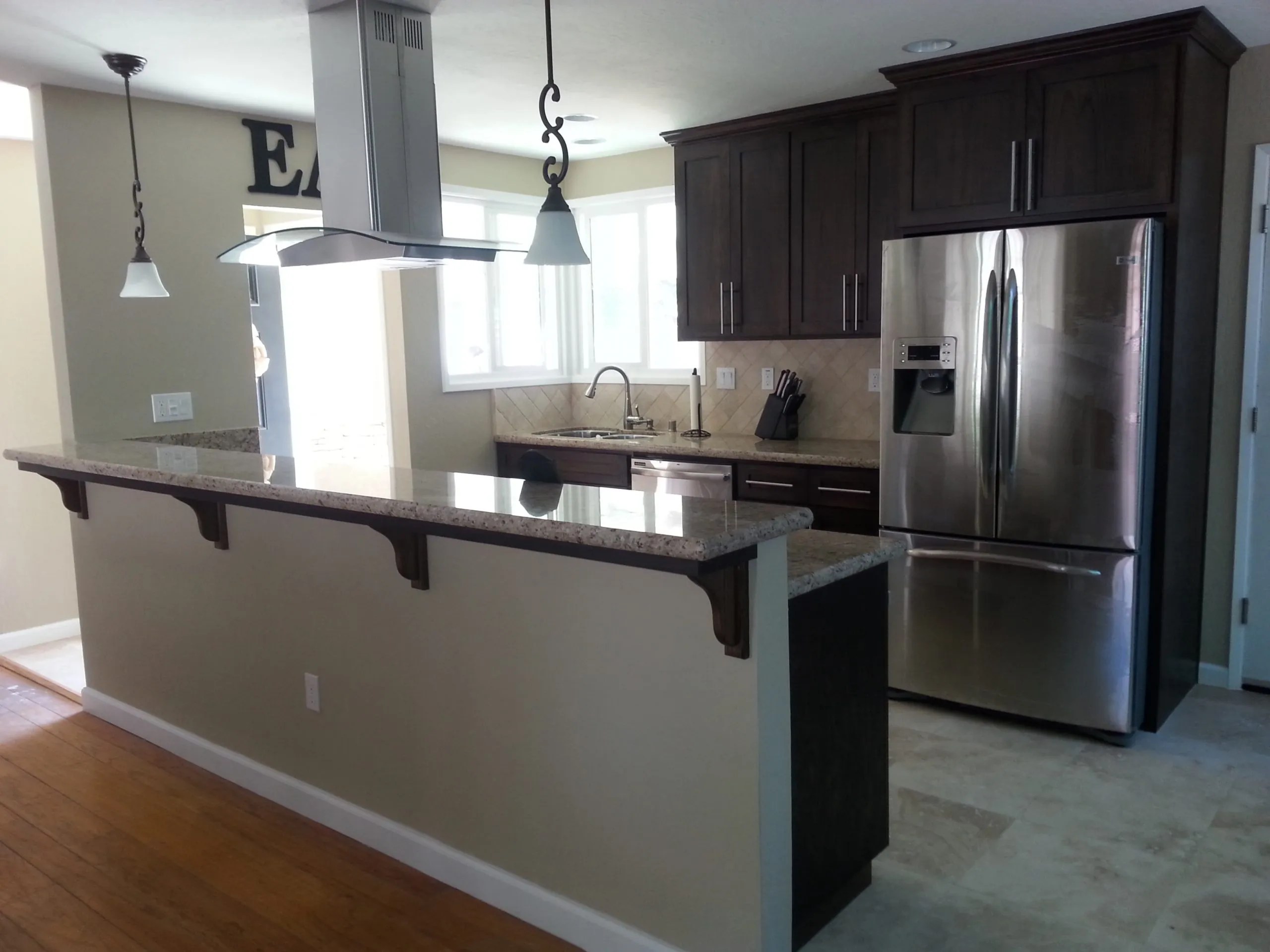 Picture of A Ramos Construction, Inc. showcases modern elegance in kitchen design with sleek granite countertops and rich cabinetry, reflecting their focus on quality outcomes. Copyright ©2025 Diamond Certified Resource - A Ramos Construction, Inc.