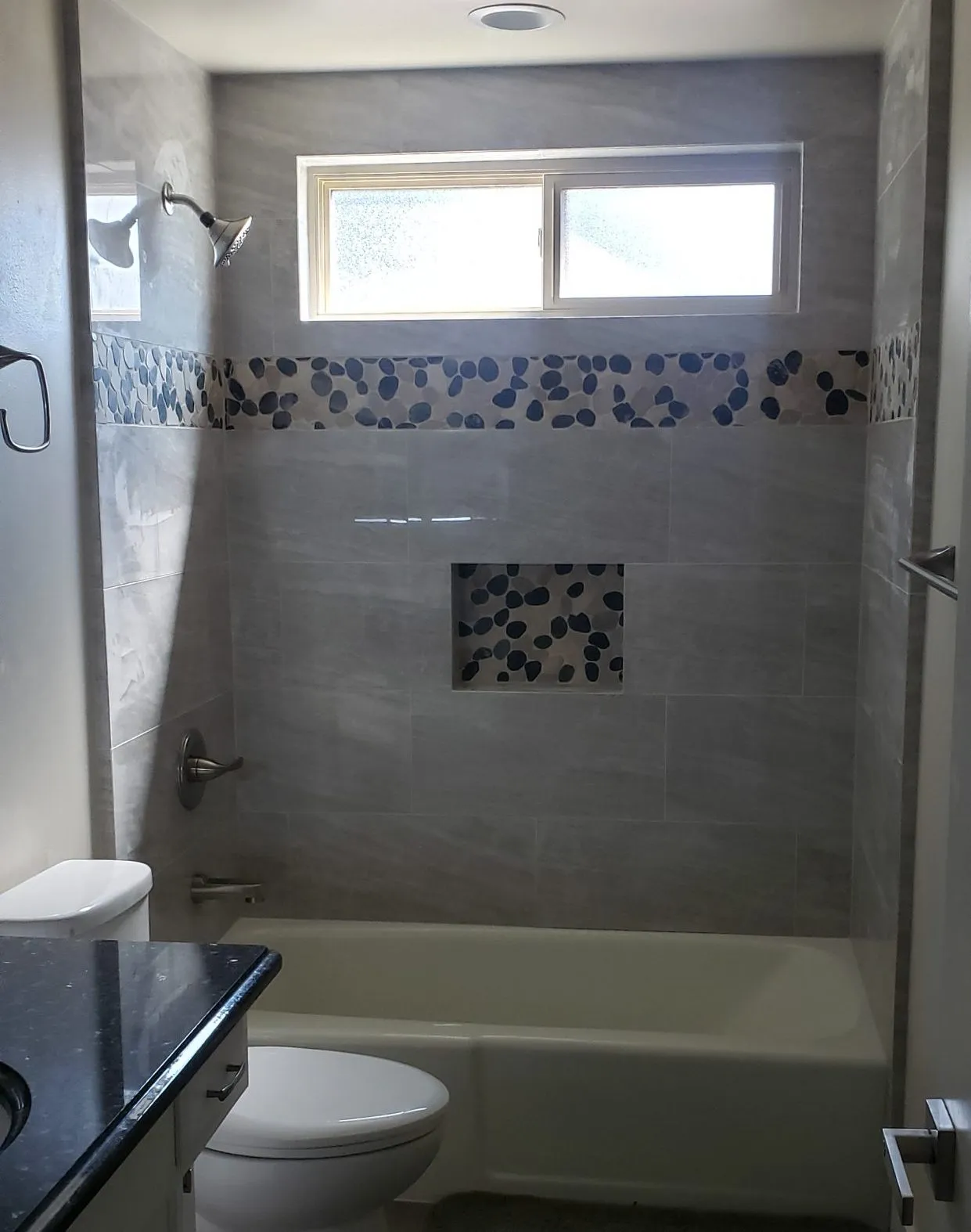 Picture of  A Ramos Construction, Inc. transforms a bathroom with sleek tiles and pebble accents, enhancing the space's elegance. Recognized for expertise and quality, they bring superior craftsmanship to life. Copyright ©2025 Diamond Certified Resource.

 - A Ramos Construction, Inc.