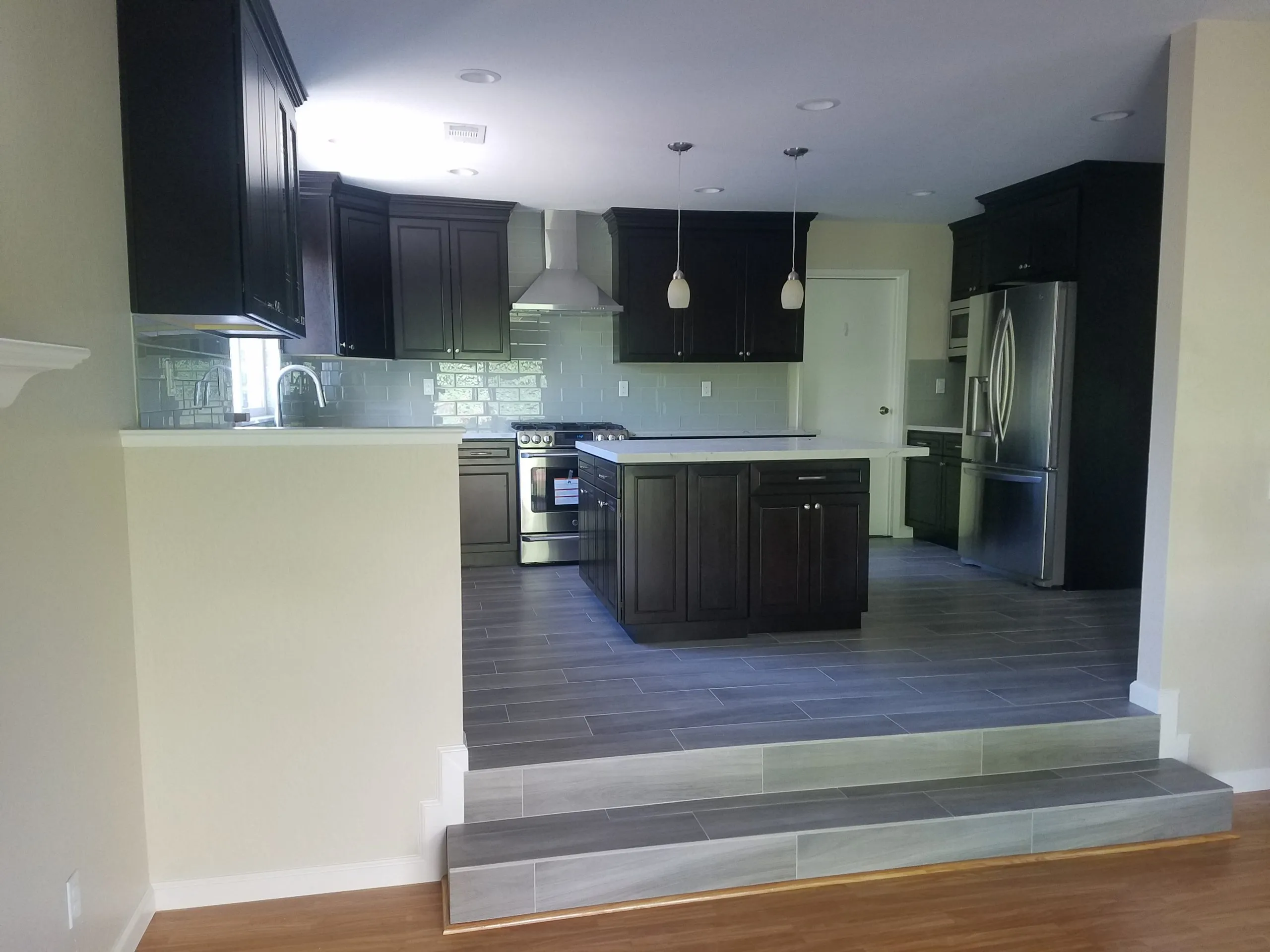 Picture of The modern kitchen remodel by A Ramos Construction, Inc. showcases sleek, dark cabinetry and state-of-the-art appliances. Their focus on quality outcomes is evident in every detail, from the polished tiles to the contemporary lighting. Copyright ©2025 Diamond Certified Resource

 - A Ramos Construction, Inc.