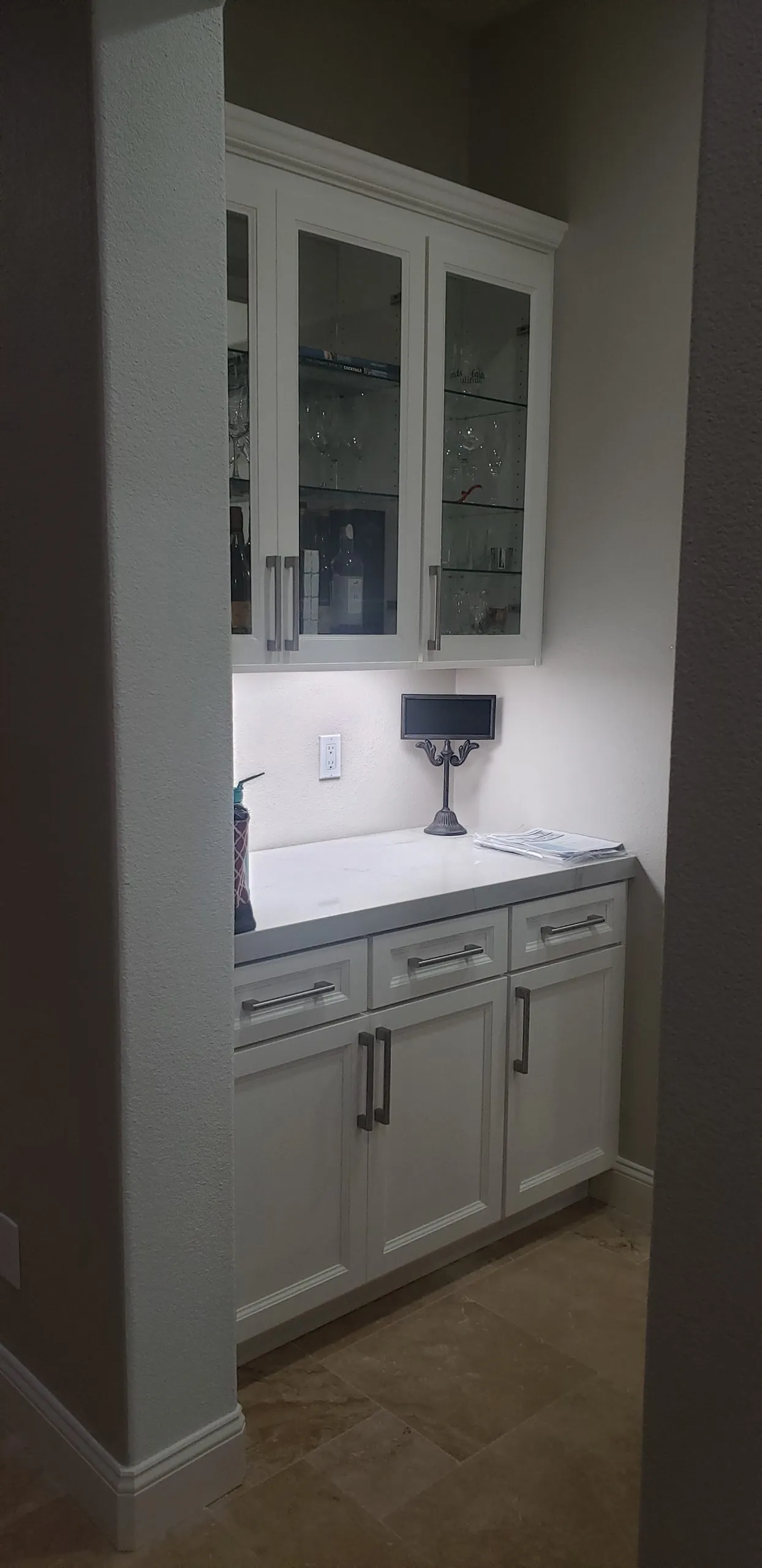 Picture of A Ramos Construction, Inc. expertly completes a sleek cabinet installation, showcasing their focus on quality outcomes. The illuminated glass shelves add a touch of elegance to the space. Copyright ©2025 Diamond Certified Resource - A Ramos Construction, Inc.