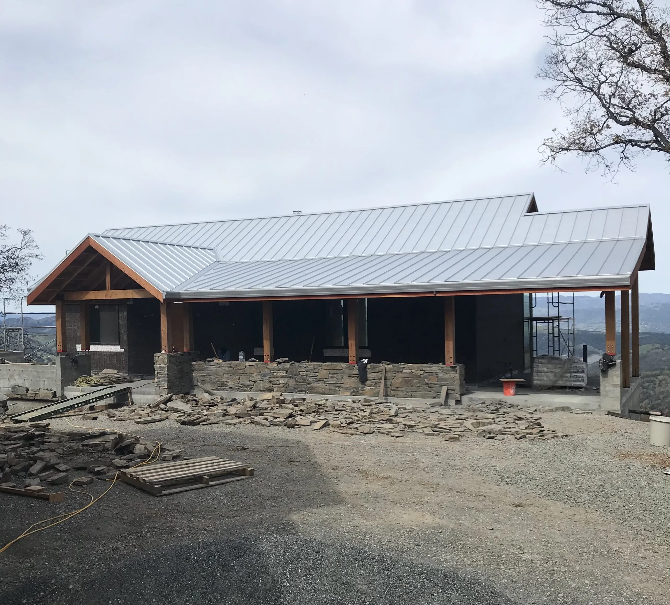 Picture of Under the expansive sky, a newly constructed roof by Crandall Roofing Inc. crowns a rustic stone structure, signaling their focus on quality outcomes. The scattered materials hint at the craftsmanship in progress. Copyright ©2025 Diamond Certified Resource

 - Crandall Roofing Inc.