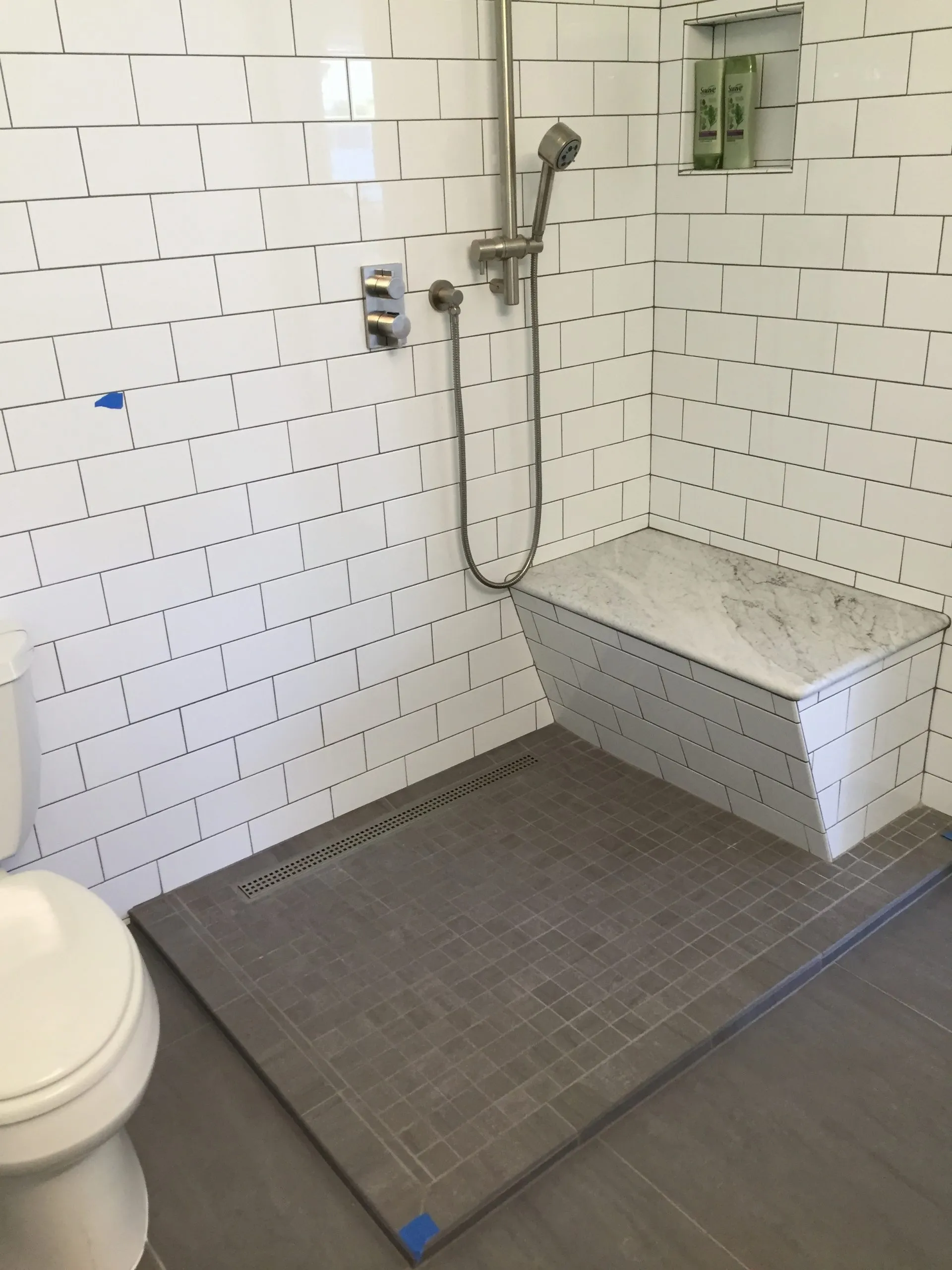 Picture of A pristine shower area showcases Green Living Builders LLC's commitment to quality outcomes with sleek tiling and functional design elements. The small niche holds essentials, reflecting thoughtful planning. The company consistently achieved a Highest in Quality rating. Copyright ©2025 Diamond Certified Resource

 - Green Living Builders LLC