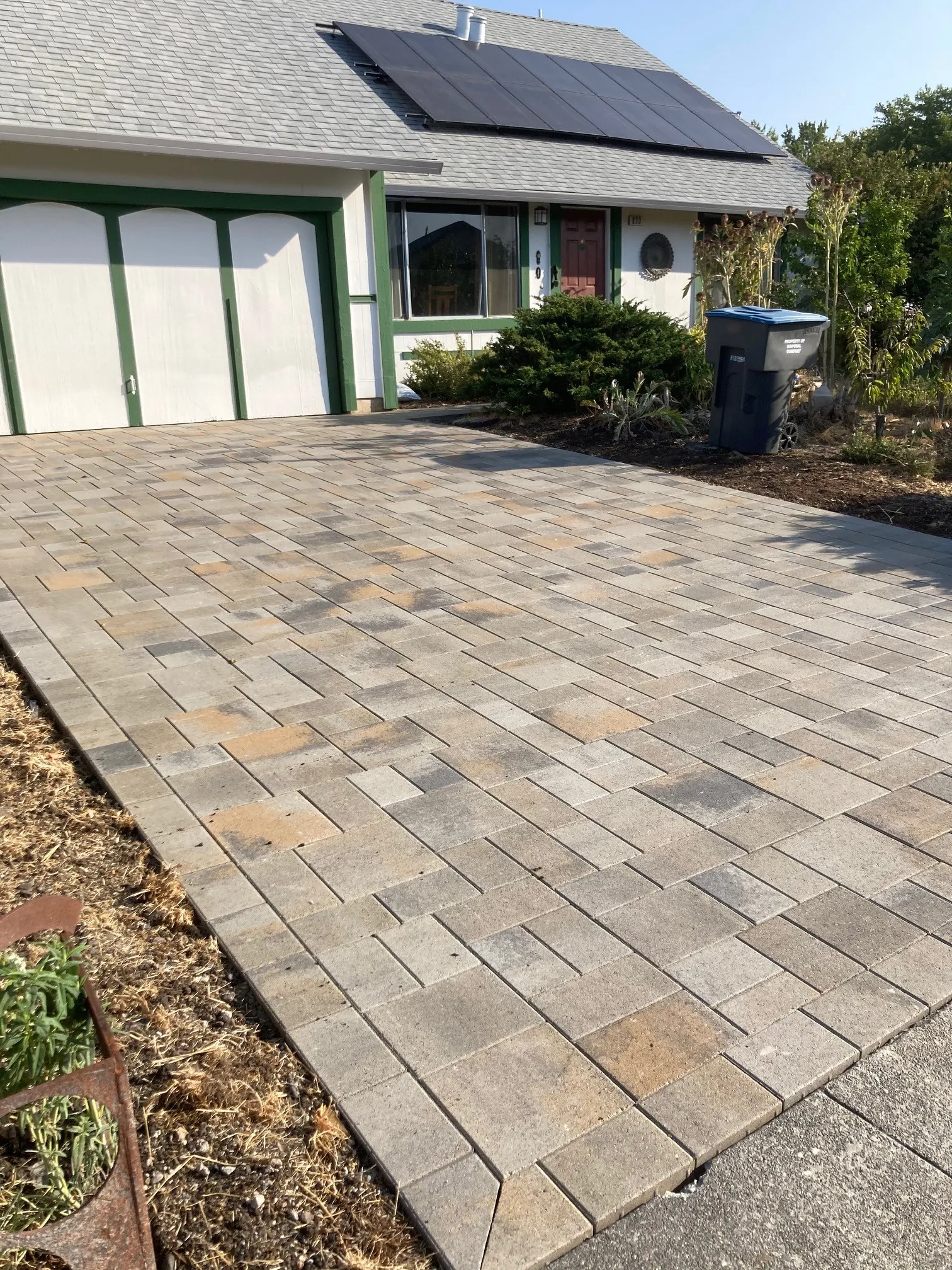 Picture of A meticulously laid stone driveway leads to a home adorned with solar panels, showcasing The Legacy Paver Group's dedication to quality outcomes. The company consistently achieves the Highest in Quality rating. Copyright ©2025 Diamond Certified Resource

 - The Legacy Paver Group