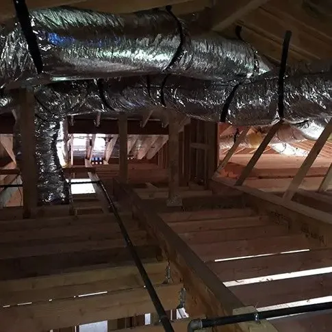 Picture of In the quiet of an unfinished attic, newly installed ductwork by Air Care Heating & Cooling, Inc. glistens under the sparse light. The company focuses on quality outcomes, ensuring optimal airflow for future comfort. Copyright ©2025 Diamond Certified Resource

 - Air Care Heating & Cooling, Inc.