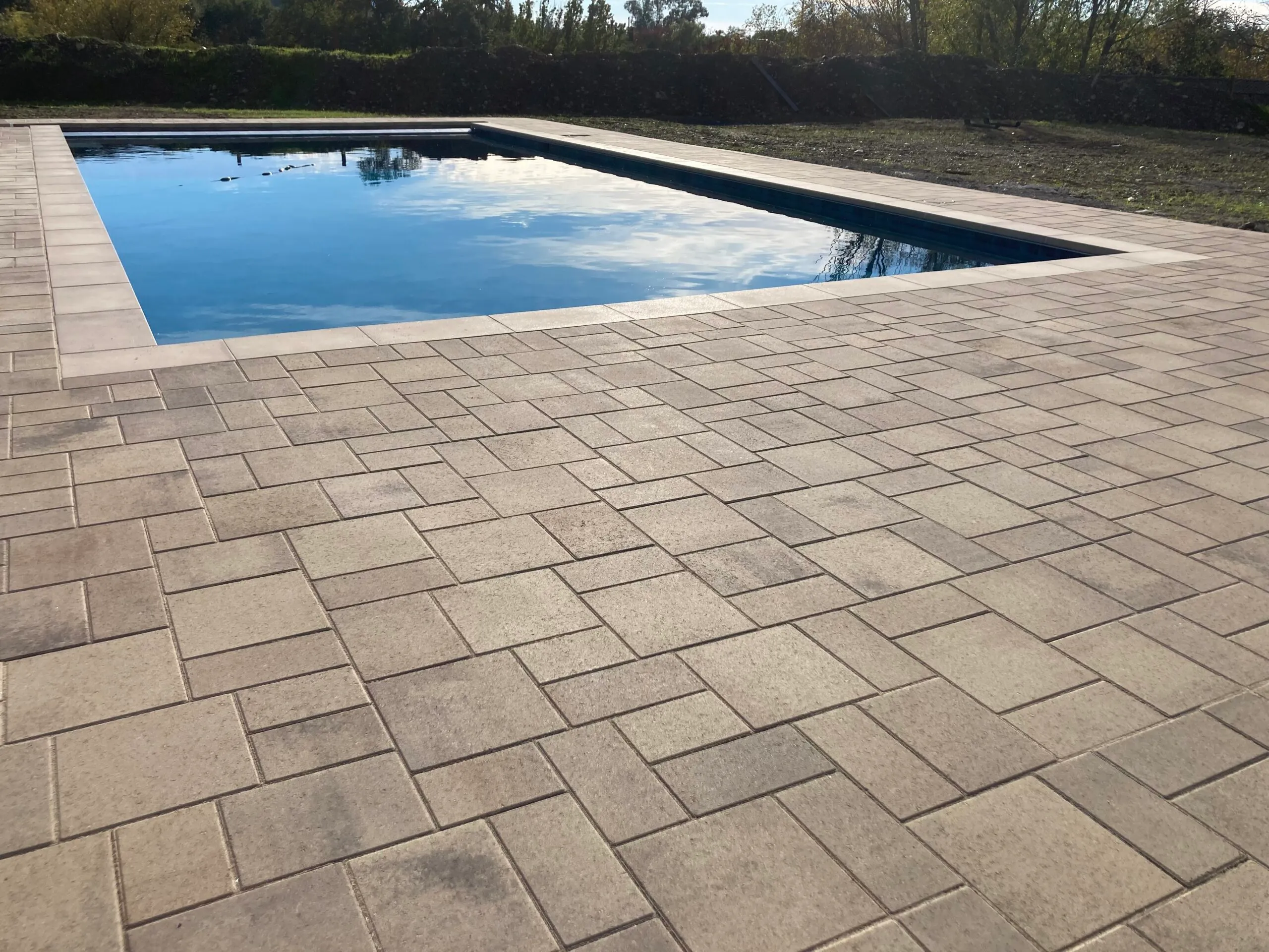 Picture of Sunlight glints off a meticulously crafted paver patio surrounding a serene pool, reflecting The Legacy Paver Group's focus on quality outcomes. Recognized for careful craftsmanship, the company scored Highest in Quality and Helpful Expertise. Copyright ©2025 Diamond Certified Resource

 - The Legacy Paver Group