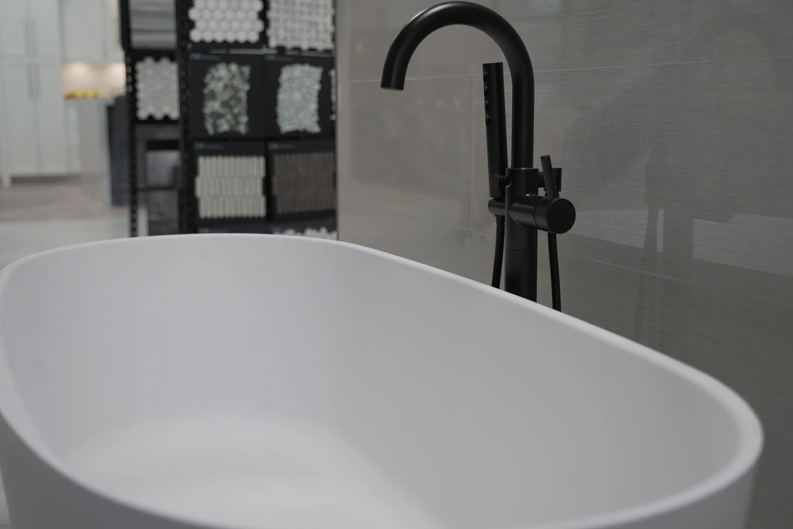 Picture of A sleek, modern bathtub sits poised for transformation against a backdrop of tile samples, embodying Today's Kitchen & Bath's commitment to quality outcomes. The companyâ€™s attention to detail ensures every bathroom renovation is a masterpiece. Copyright ©2025 Diamond Certified Resource - Today's Kitchen & Bath