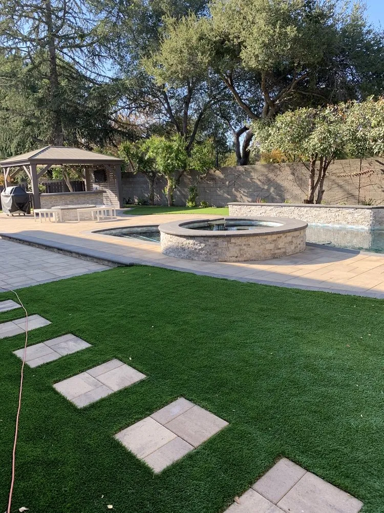 Picture of A serene backyard oasis features a custom-built water feature and gazebo, showcasing ARP Hardscape's focus on quality outcomes. This tranquil setting highlights the expertise behind their top-rated quality. Copyright ©2025 Diamond Certified Resource - ARP Hardscape