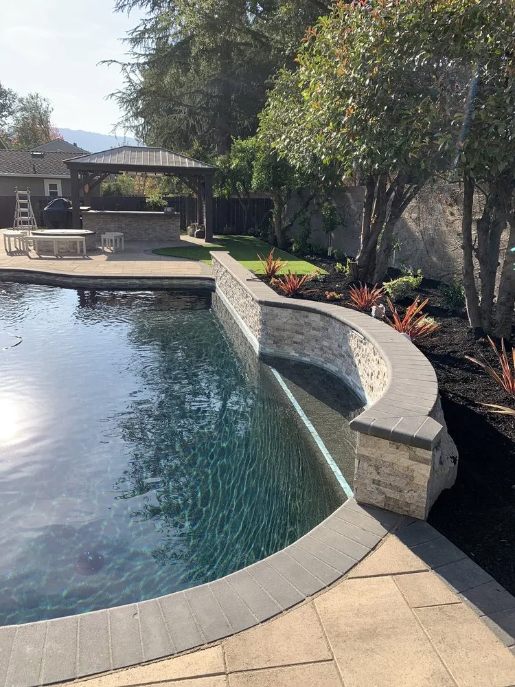 Picture of ARP Hardscape invites tranquility with a gracefully curved poolside, reflecting their expertise in creating serene outdoor retreats. Known for high customer satisfaction ratings, they transform spaces with precision and care. Copyright ©2025 Diamond Certified Resource - ARP Hardscape