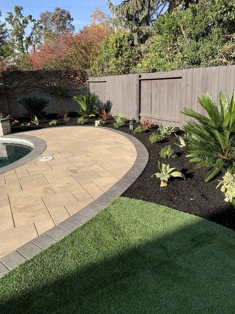 Picture of In a tranquil backyard transformation, ARP Hardscape crafts a seamless blend of stone and greenery, reflecting their focus on quality outcomes. The meticulous landscaping highlights the serene curve of a patio, inviting relaxation. Copyright ©2025 Diamond Certified Resource

 - ARP Hardscape