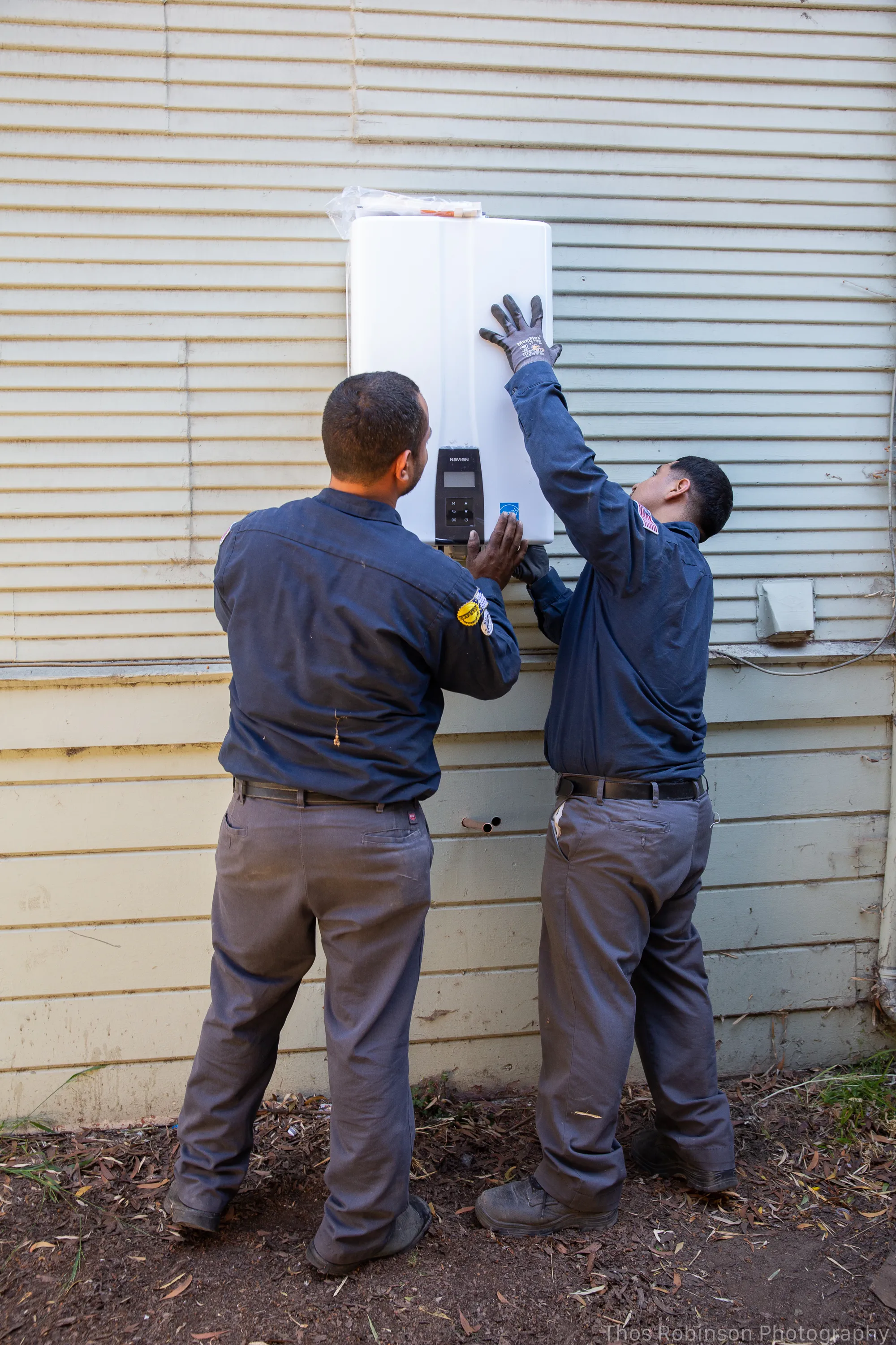 Picture of In a quiet moment of precision and teamwork, two technicians from Big Blue Plumbing install a tankless water heater, underscoring their commitment to quality outcomes. Copyright ©2025 Diamond Certified Resource

 - Big Blue Plumbing