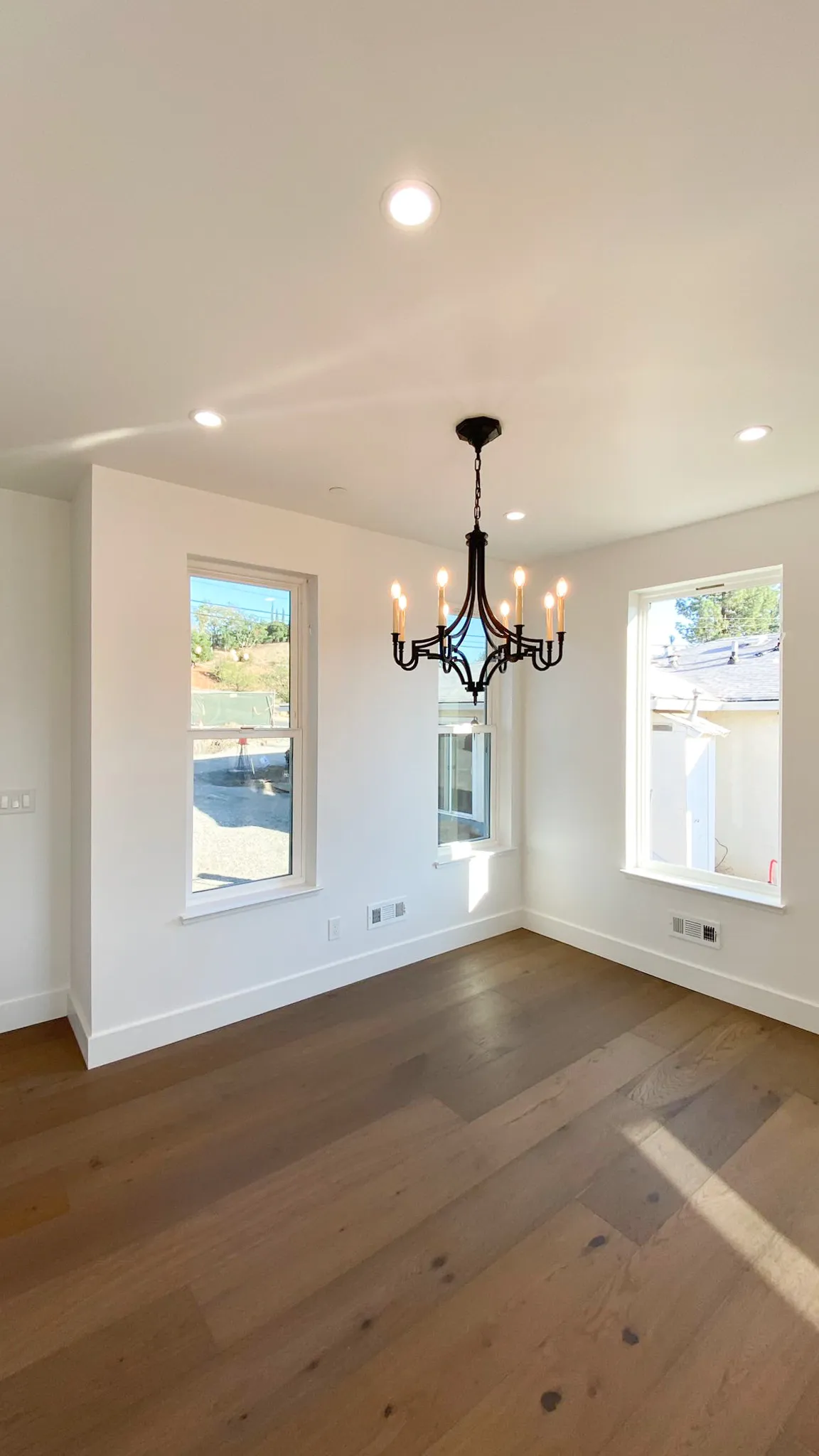 Picture of A newly completed room by Mana Construction Inc. showcases a minimalist elegance with its sleek chandelier and pristine hardwood floor, reflecting the companyâ€™s focus on quality outcomes. Copyright ©2025 Diamond Certified Resource

 - Mana Construction Inc.