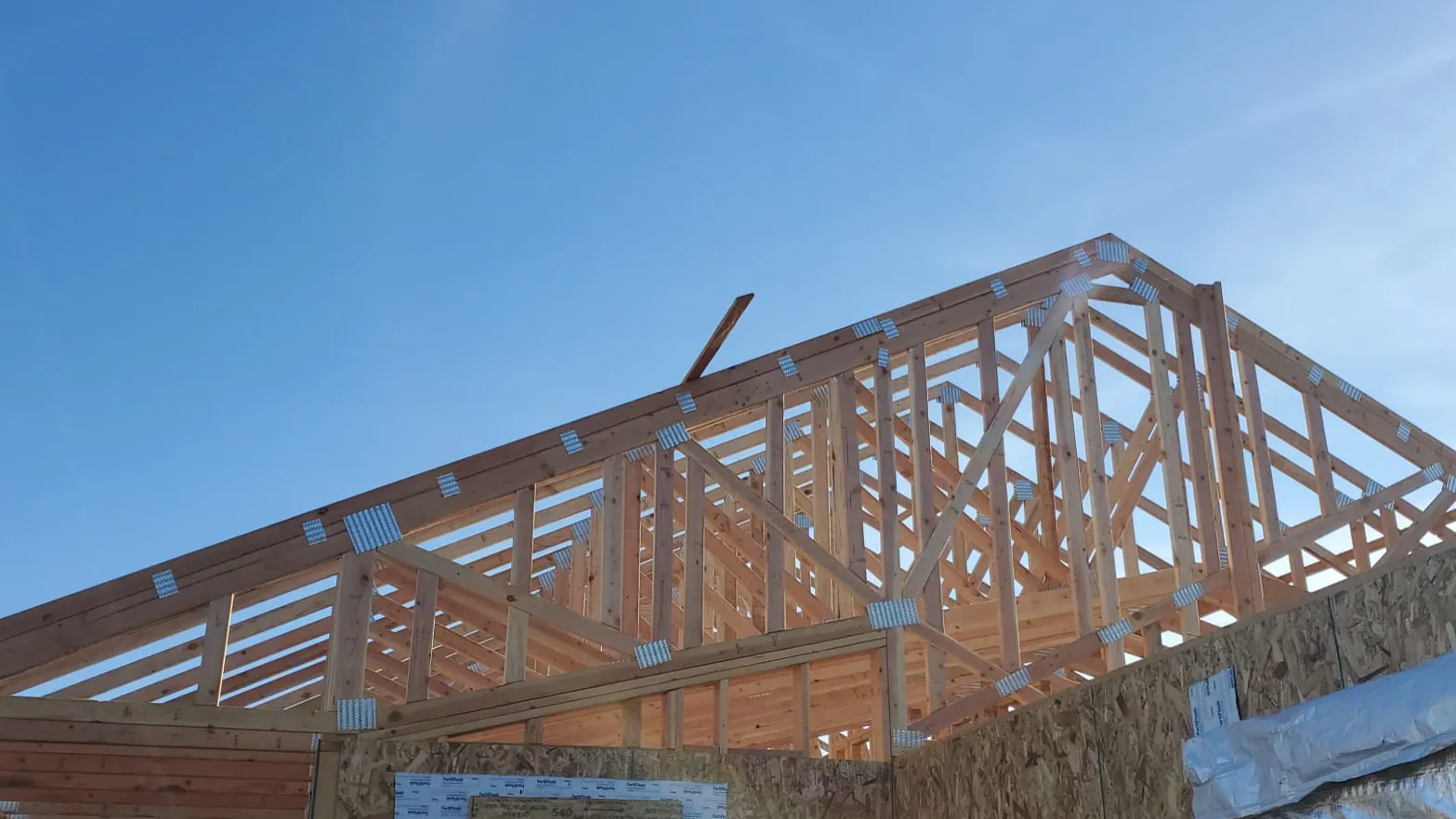 Picture of A well-constructed wooden framework stands against the clear sky, embodying Mana Construction Inc.'s commitment to design precision and structural integrity. Recognized for expertise and quality, their craftsmanship is evident here. Copyright ©2025 Diamond Certified Resource

 - Mana Construction Inc.