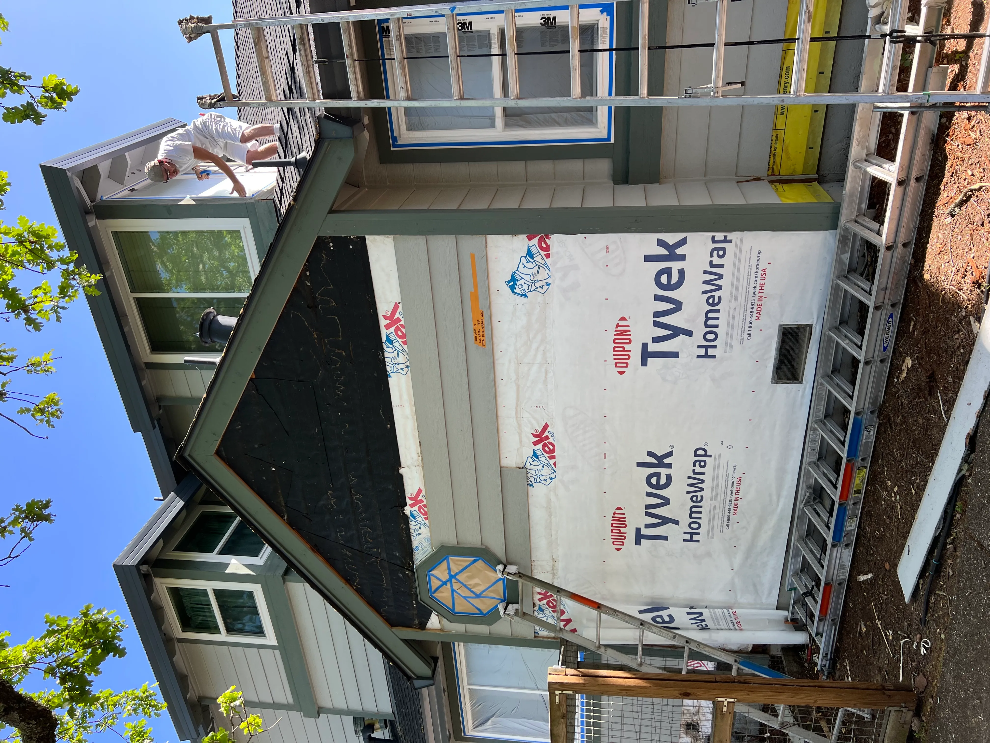 Picture of A dedicated worker paints the upper trim of a house, surrounded by the structure's protective Tyvek HomeWrap. Solidarity Painting, Inc. consistently achieves a Highest in Quality rating, ensuring excellence in every stroke. Copyright ©2025 Diamond Certified Resource

 - Solidarity Painting, Inc.
