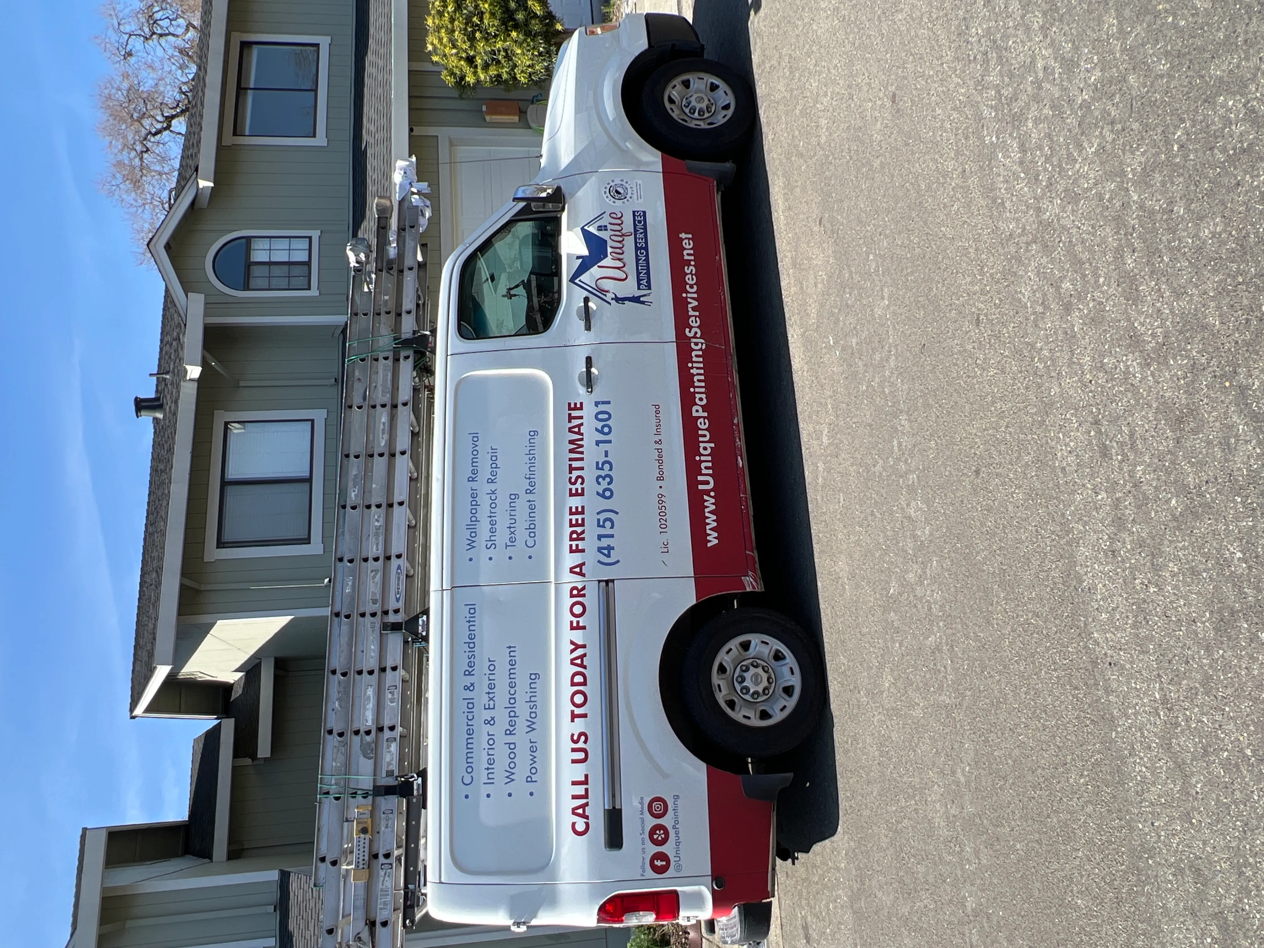  A van labeled "Unique Painting Services" with ladders on top is parked in front of a house, highlighting home painting preparation.